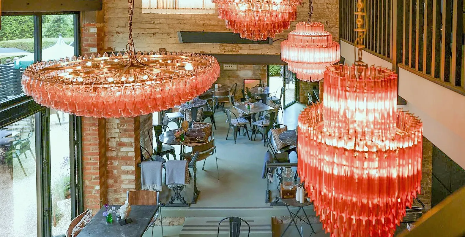 Coral glass chandeliers hanging over the tables of the Hop Kiln Café